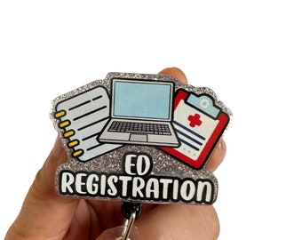 Può includere: Portabadge in glitter argento con un cordino retrattile nero. Il badge presenta un laptop, una clipboard con una croce rossa e un blocco note. Il testo "ED REGISTRATION" è stampato sul badge.