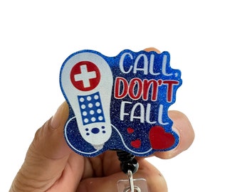 Może przedstawiać: Błękitny i czerwony błyszczący brelok do odznaki z białym symbolem medycznym i tekstem "CALL, DON'T FALL".