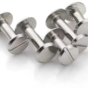 May include: A set of six silver-toned metal screw-on fasteners with a flat head and a threaded shaft. The fasteners are designed for attaching fabric or other materials to a surface.