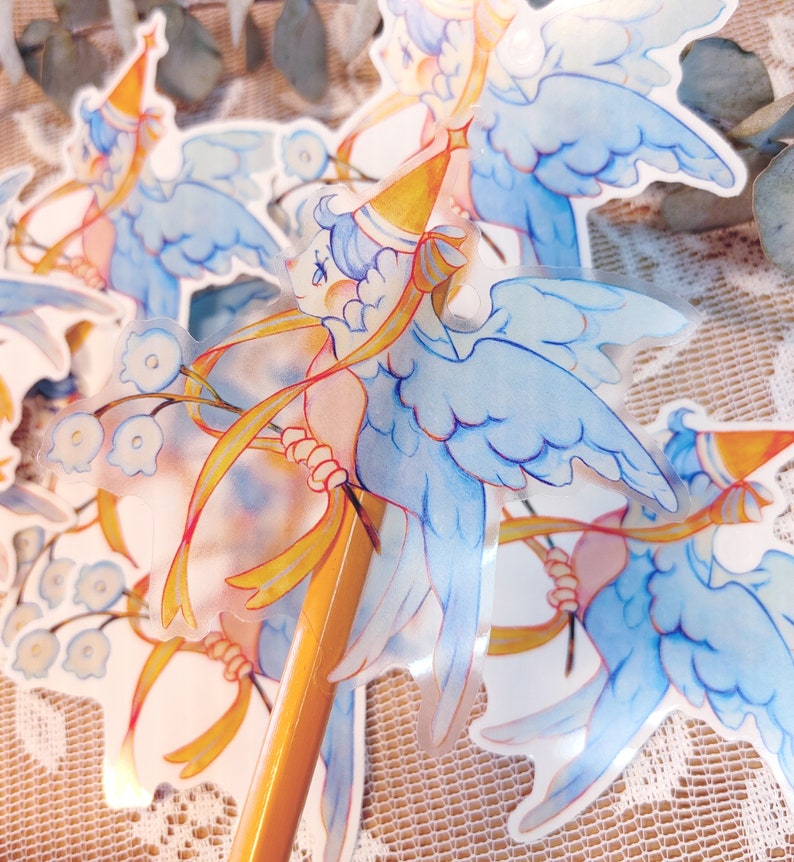 May include: A set of four clear stickers featuring a whimsical illustration of a blue bird with wings, wearing a party hat and holding a yellow ribbon. The bird is surrounded by blue flowers.