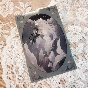 May include: A watercolor illustration of two mermaids with long flowing hair, one with dark hair and the other with white hair, embracing in a swirling sea of blue and white. The mermaids are surrounded by small fish and stars.