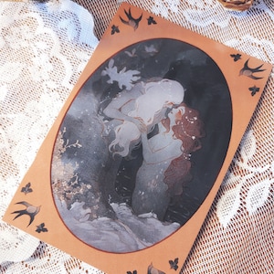 May include: A watercolor illustration of two figures embracing in a dark forest setting. The figures are depicted in a romantic pose, with the woman's hair flowing down her back and the man's arm around her waist. The background is a dark forest with trees and foliage. The illustration is framed in a brown oval with a white border. There are small black birds with white wings on the corners of the frame.