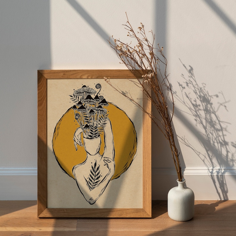 Peut inclure: Une impression encadr&eacute;e avec un cercle jaune et une illustration en noir et blanc d'une personne avec des champignons qui poussent sur sa t&ecirc;te. L'impression est sur un fond brun clair et a un cadre en bois.