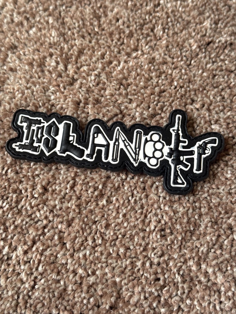 Pode incluir: Patch preto e branco com a palavra "ISLAND" e ilustra&ccedil;&otilde;es de armas. O patch apresenta um fundo preto com contornos e detalhes brancos, incluindo uma faca, soqueiras e armas de fogo.