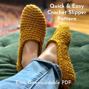 May include: A pair of yellow crocheted slippers with a button detail. The slippers are worn by a person sitting on a green ottoman. The text "Quick & Easy Crochet Slipper Pattern" and "Easy Downloadable PDF" is visible in the image.