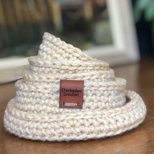 Peut inclure: Ensemble de cinq sous-verres en crochet beige avec une étiquette en cuir marron qui indique "Chickadee Crochet".