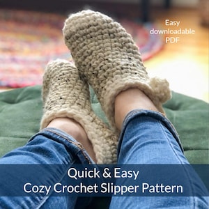 Puede incluir: Un par de zapatillas de crochet acogedoras de color crema con una textura moteada. Las zapatillas son usadas por una persona que lleva pantalones vaqueros azules. El texto "Quick & Easy Cozy Crochet Slipper Pattern" está en la parte inferior de la imagen. El texto "Easy downloadable PDF" está en la parte superior de la imagen.