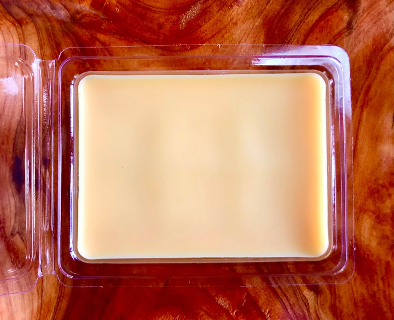 May include: A clear plastic container with a lid, containing a solid, pale yellow wax block.