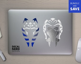 May include: Two vinyl decals for a laptop or other smooth surface. The left decal is a blue and white Mandalorian symbol. The right decal is a white and gray helmet with a visor. The decals are from Decal Nerd Design.