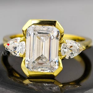 3ct Lab Grown Diamond Emerald Cut 18kt Gold Bezel Set Engagement Ring