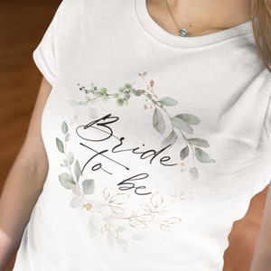 Bride to be t-shirt in a modern, delicate gold-green leaf design for the JGA, classic white cotton t-shirt in unisex cut