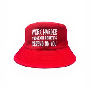 May include: A red bucket hat with the white text: "WORK HARDER, THOSE ON BENEFITS DEPEND ON YOU." The hat is made of a soft material and has a wide brim. The hat is a solid red colour.