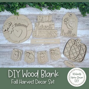 May include: A DIY Fall Harvest Decor Set featuring unfinished wood cutouts. Includes a round piece with an acorn, a tag with a floral design, a pumpkin, and banner pieces. The set also has the words "FALL", "Harvest", and "Blessings".
