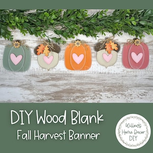 May include: A DIY wood blank fall harvest banner featuring five wooden cutouts. The cutouts include pumpkins and acorns in shades of green, orange, and pink, each with a heart and decorative accents. The banner is set against a rustic wood background.