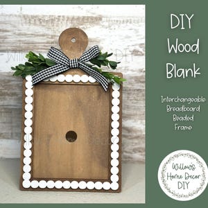 May include: A wooden DIY breadboard frame with a scalloped white border and a black and white checkered bow. The frame has a hole in the center and is decorated with greenery. Text on the right reads "DIY Wood Blank".