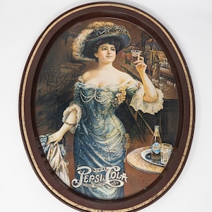 May include: A vintage metal serving tray with a brown rim and a colorful image of a woman in a blue dress holding a glass of Pepsi-Cola. The tray features the text "Drink Pepsi-Cola Delicious-Healthful 15c".