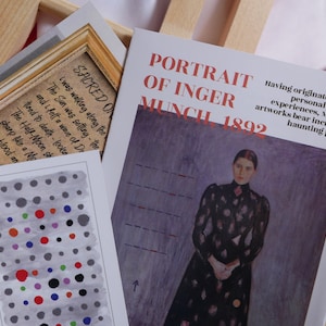 May include: A close-up of a book cover with the title "Portrait of Inger Munch 1892". The cover features a painting of a woman in a black dress with a patterned design, standing against a purple background. The text "Having originated in his personal painful experiences, Munch's artworks bear incredible haunting power" is printed below the painting.