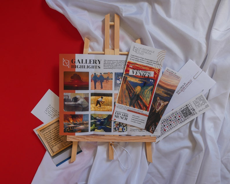 May include: A white easel displaying a gallery highlights brochure featuring a variety of artwork, including a painting of a screaming figure, a painting of a man in a field, and a painting of a sunset. The brochure also includes the text "Gallery Highlights" and "Edward Munch".