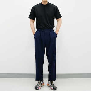 May include: A black short-sleeved t-shirt paired with dark blue pleated pants and colorful athletic shoes.