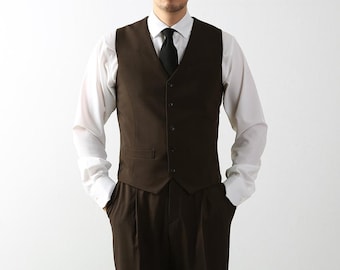 May include: A brown vest with a black tie and a white dress shirt. The vest has a V-neck and five buttons.