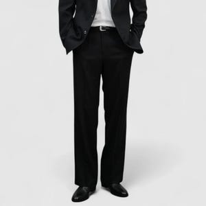 May include: A black suit, consisting of a blazer and matching trousers, paired with a white t-shirt. The blazer has a notched lapel and the trousers are straight-legged. A black belt is visible. The outfit is completed with black shoes.
