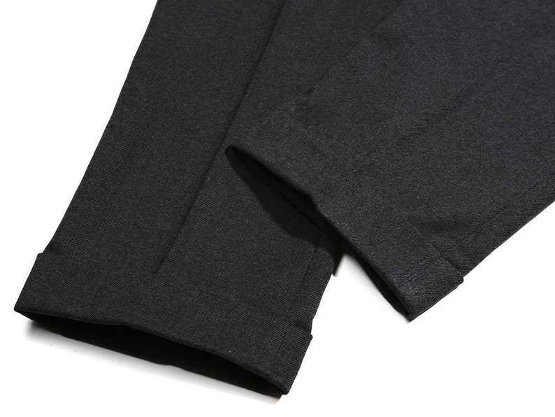 K&ouml;nnte beinhalten: Nahaufnahme des Saums einer schwarzen Hose. Der Stoff ist ein weicher, strukturierter Strick.