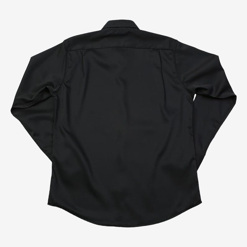 May include: A black long-sleeve shirt with a button-down collar. The shirt is made of a smooth, solid-colored fabric. The back of the shirt is visible, showing the yoke and the curved hemline. The sleeves are long and end in a buttoned cuff.