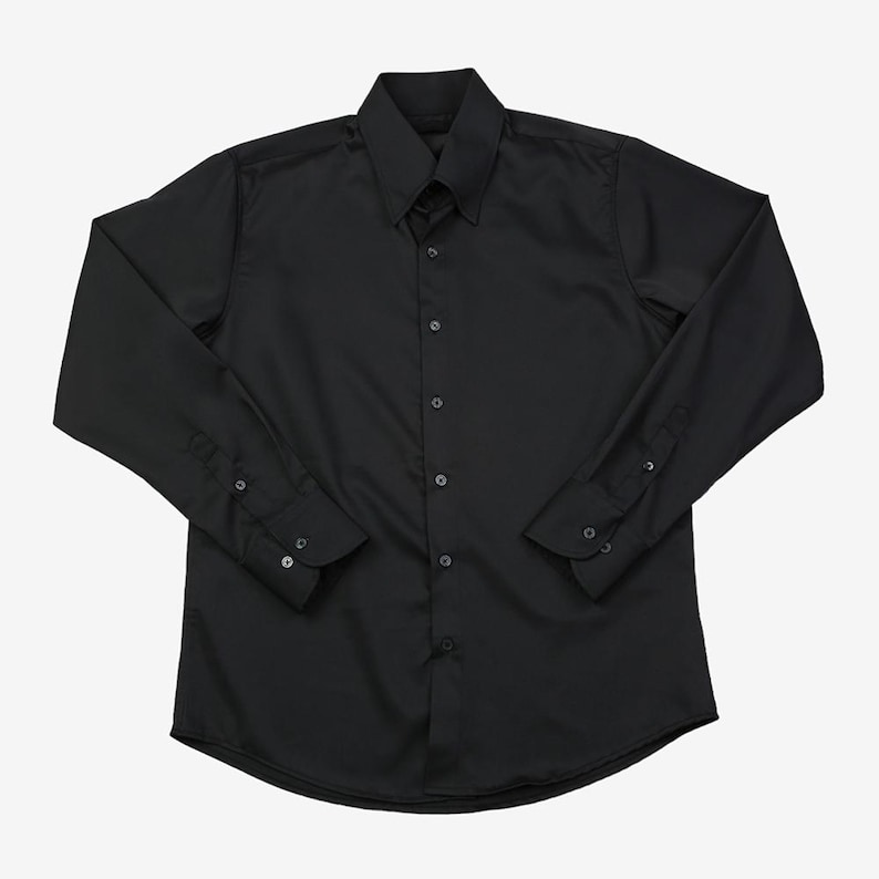 May include: A solid black long-sleeve button-down shirt. The shirt has a classic collar, buttoned cuffs, and a curved hem. The shirt is made of a smooth, opaque fabric.