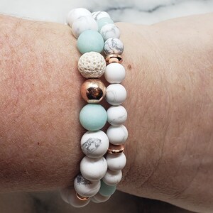 May include: Two bracelets with white and light blue beads, gold spacers, and a lava rock bead.
