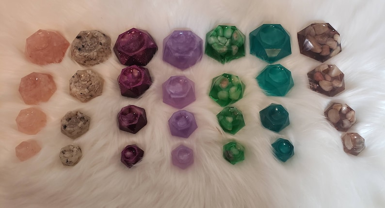 May include: A set of 30 small, geometric resin trinket dishes in various colors, including pink, white, purple, green, and brown. Each dish has a different design and features a variety of inclusions, such as glitter, shells, and stones.