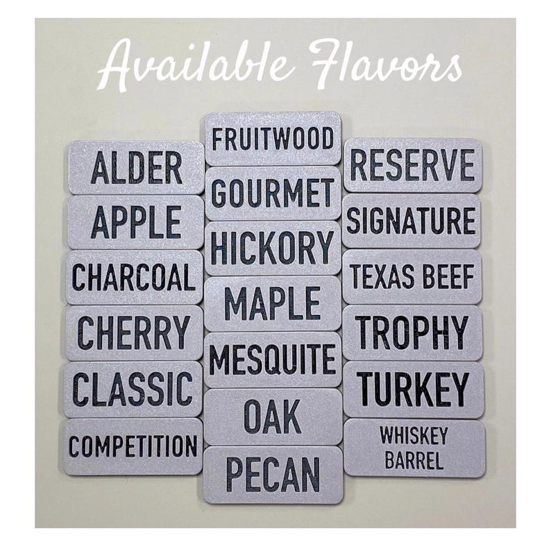 May include: A collection of silver metal labels with black text listing various wood and other flavours. The labels are arranged in two columns with the text "Available Flavours" at the top.