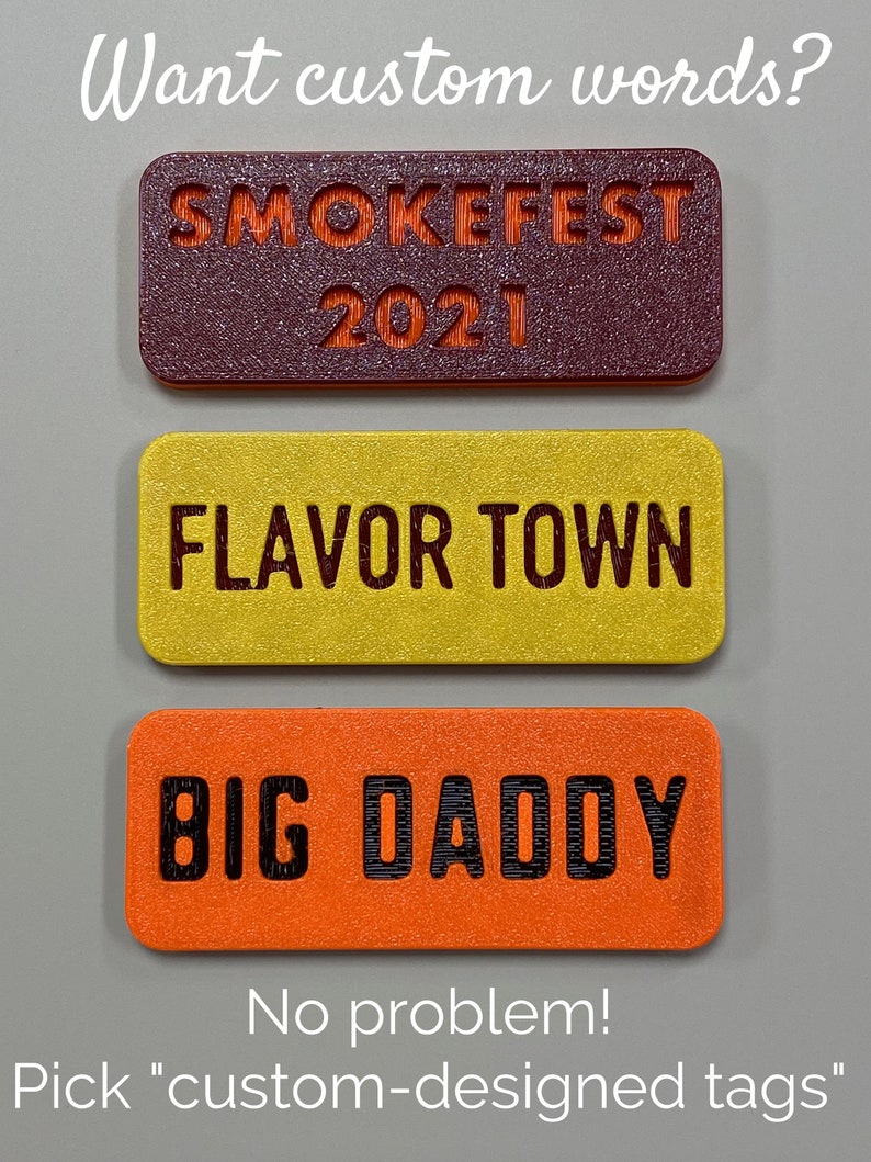 May include: Three rectangular tags with different text and colours. The top tag is maroon with orange text that says "SMOKEFEST 2021". The middle tag is yellow with black text that says "FLAVOR TOWN". The bottom tag is orange with black text that says "BIG DADDY".