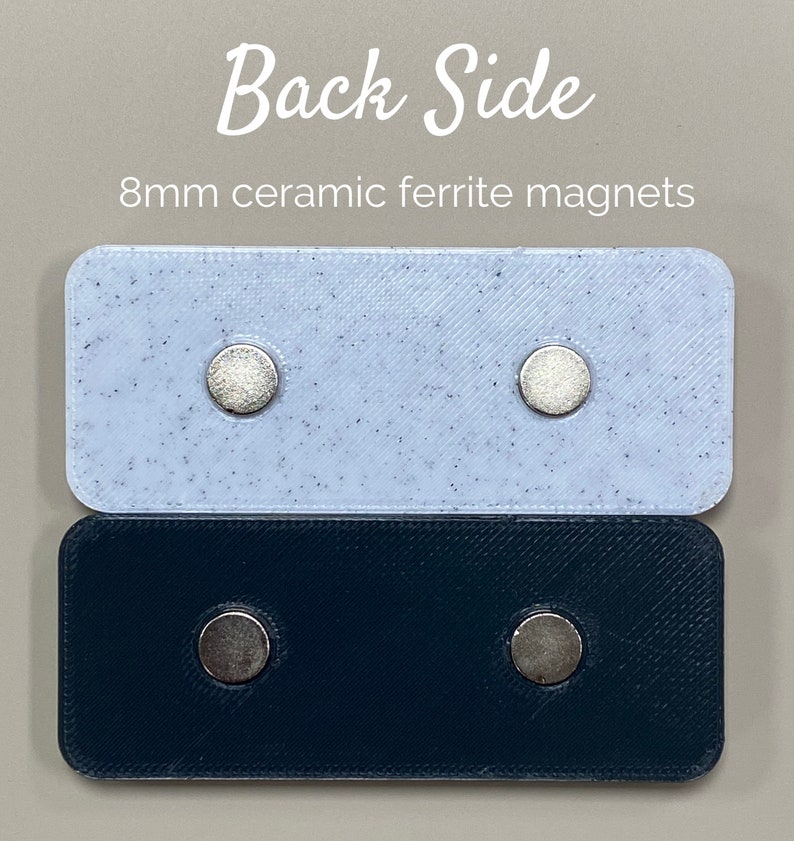 May include: Two rectangular pieces of plastic, one white with black speckles and one black, each with two 8mm ceramic ferrite magnets attached to the back side.