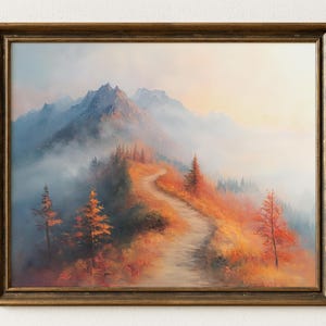 Pode incluir: Pintura de paisagem emoldurada que retrata uma cordilheira na névoa. Um caminho sinuoso leva através de uma encosta de folhagem laranja e vermelha. A obra de arte está emoldurada em uma moldura dourada, evocando calor e tranquilidade.
