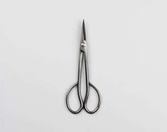 May include: A pair of silver-toned pruning shears with a curved blade and a pointed tip.