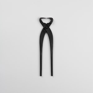 May include: Black pruning shears with a curved blade and a spring-loaded handle.