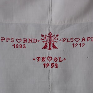 May include: White fabric with red embroidered text and a tree design. The text reads "PPS ♥ HND 1882", "PLS ♥ APD 1919", and "TK ♥ GL 1952".