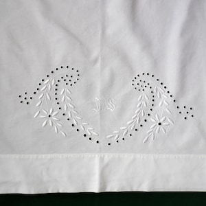May include: White cotton pillowcase with a delicate embroidered design featuring two floral motifs and the initials "J.S."
