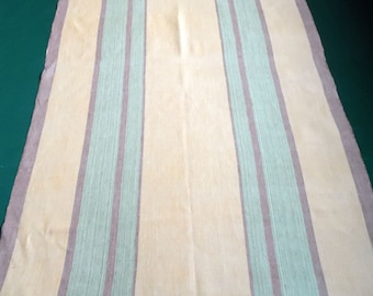 May include: A striped throw blanket with alternating beige and green stripes. The blanket is made of a soft, woven fabric.