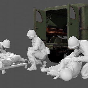 May include: A group of four white plastic figurines depicting soldiers tending to a wounded soldier on a stretcher. The soldiers are wearing helmets and military uniforms. A green military ambulance with a red cross is in the background.
