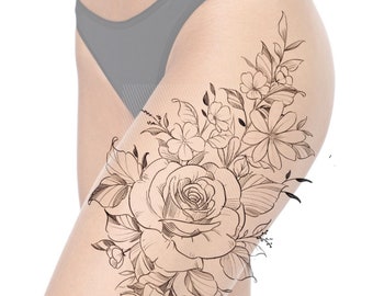 Può includere: Un disegno in bianco e nero di un design di tatuaggio floreale con una grande rosa e fiori più piccoli. Il design del tatuaggio è sulla coscia di una donna.