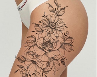 Può includere: Design di tatuaggio in bianco e nero a linea d'arte di un bouquet di fiori con una grande rosa, una margherita e fiori più piccoli. Il design è sulla coscia di una persona.