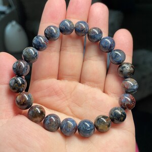 May include: A bracelet made of blue and brown tiger's eye beads.