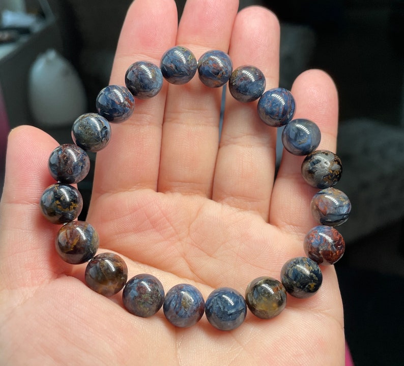 May include: A bracelet made of blue and brown tiger's eye beads.