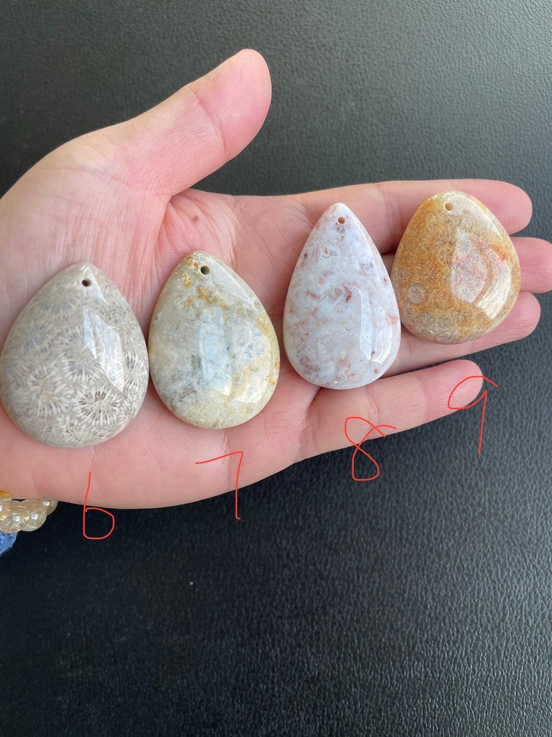Puede incluir: Cuatro colgantes de coral fosilizado en varios tonos de marr&oacute;n, blanco y beige. Los colgantes tienen forma de l&aacute;grima y tienen un agujero perforado en la parte superior para colgar.