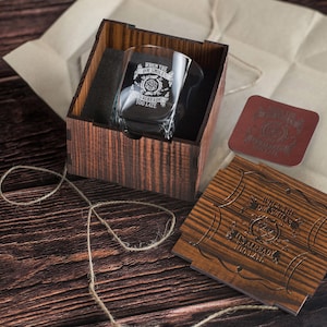 Könnte beinhalten: Eine Holzkiste mit einem Glas darin. Das Glas trägt die Inschrift "Wenn die Lächeln schon zu spät sind". Die Kiste ist geöffnet und das Glas ist sichtbar. Neben der Kiste befindet sich ein kleiner Holz-Untersetzer mit einer ähnlichen Inschrift.