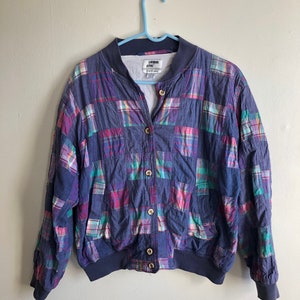 May include: A blue and purple plaid bomber jacket with a button closure. The jacket has a London Fog label.