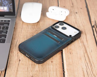 May include: A dark blue leather smartphone case with a built-in card holder slot on the back, featuring visible stitching along the edges and a black frame surrounding the camera lenses and the sides of the device, holding two black cards.
