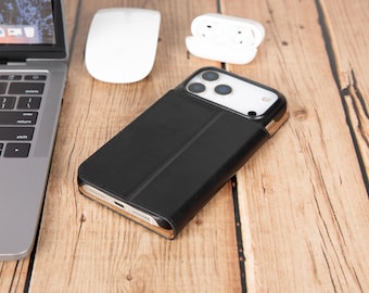 May include: A black leather-style smartphone wallet case featuring a smooth exterior finish, a vertical fold line, and a cutout for the triple-lens camera system. The case is shown covering the back of a smartphone, revealing the bottom charging port.