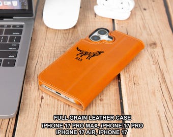 May include: An orange full-grain leather phone case with a stylized animal design and the name "DAN" engraved on the front. The case is designed for iPhone 17 Pro Max, 17 Pro, 17 Air, and 17 models.